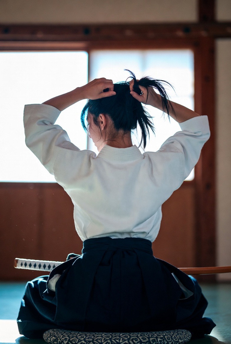 Young Woman in Traditional Martial Arts Attire in Pose, People, nanoBanana-Pro, Cross-Back Pose, Japanese Dojo reference image